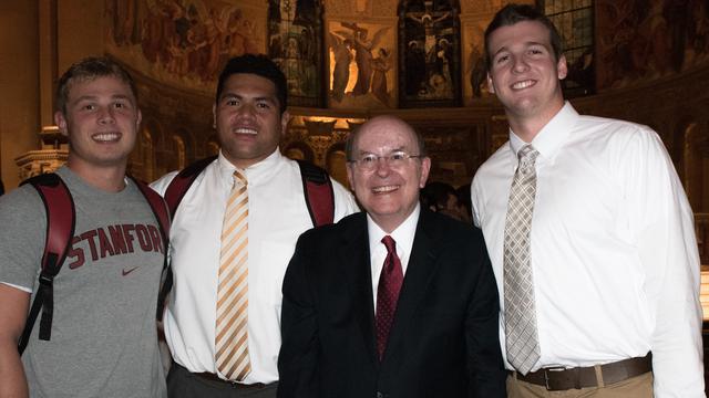 Quentin L. Cook pose avec trois membres de l'équipe de football de l'Université de Stanford.