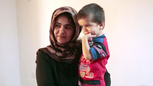 Une femme réfugiée portant son enfant.