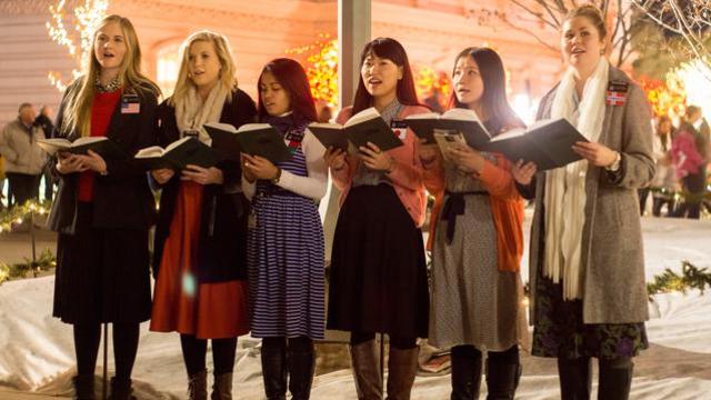 Des Missionnaires servant à Temple Square chantent des cantiques de Noël pour les gens venus pour célébrer le début de la saison de Noël.
