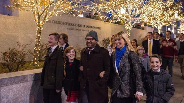 Une famille et d'autres visiteurs vont à pied au centre de conférence pour la veillée de Noël de la Première Présidence, le 7 Décembre, 2014.